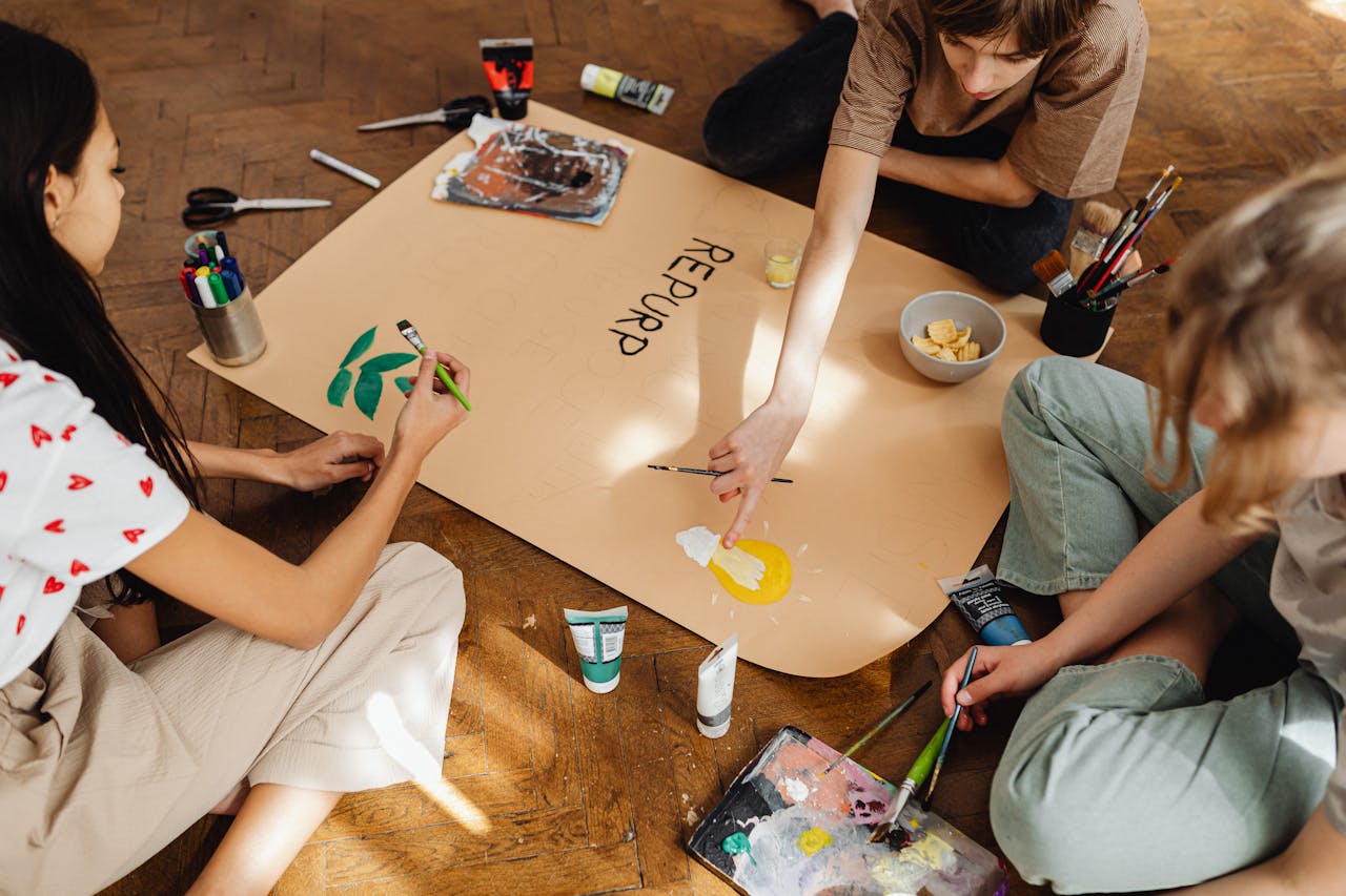 gallery-4 Group of teenagers working on an artistic project indoors with art supplies.